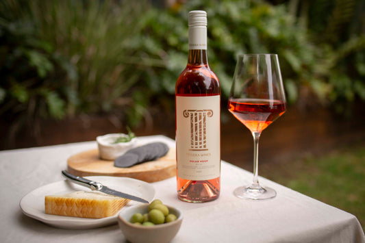 bottle of Tessera Wines Hulah Hoop Rosé 2025 with a filled wine glass on an outdoor table, served alongside cheese, olives, and crackers — the best Australian Rosé to drink during summer.